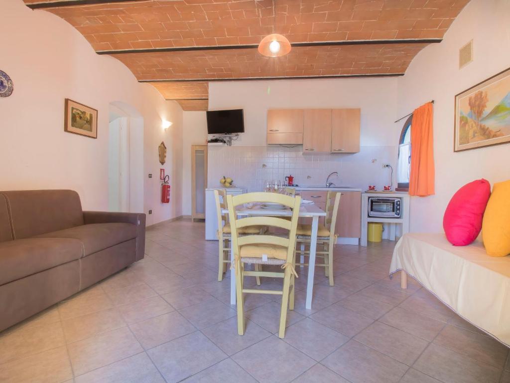 salon z kanapą i stołem oraz kuchnia w obiekcie Apartment Il Secondo-1 by Interhome w mieście Bibbona