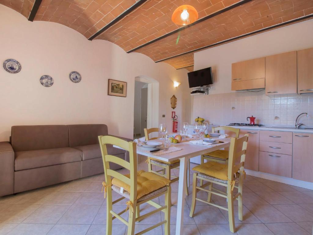 kuchnia i salon ze stołem i krzesłami w obiekcie Apartment Il Secondo-1 by Interhome w mieście Bibbona