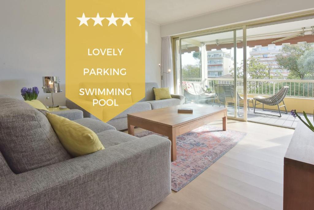 un salon avec un canapé et une table dans l'établissement 2-Br Apartment with pool & garage - 10 min walk to center, à Cannes