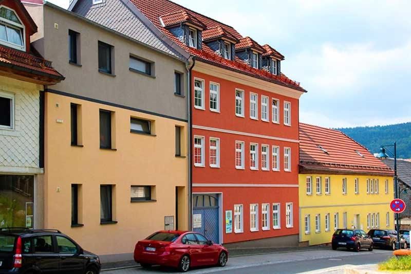 a red car is parked in front of some buildings at Ferienwohnung Bernhardt in Zella-Mehlis