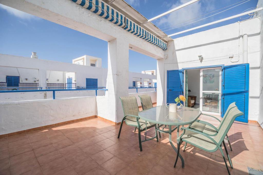 ein Esszimmer mit einem Tisch und Stühlen auf dem Balkon in der Unterkunft Apartamento Almadraba in Chiclana de la Frontera