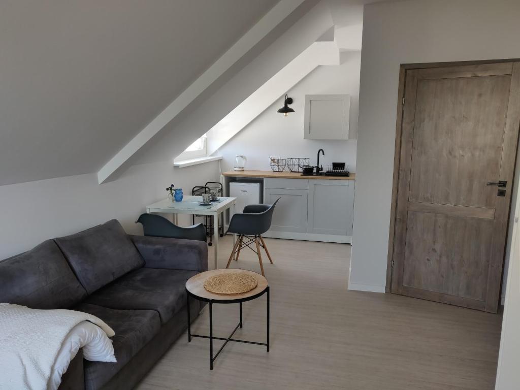 a living room with a couch and a kitchen at Ostrowianka in Ostrowo