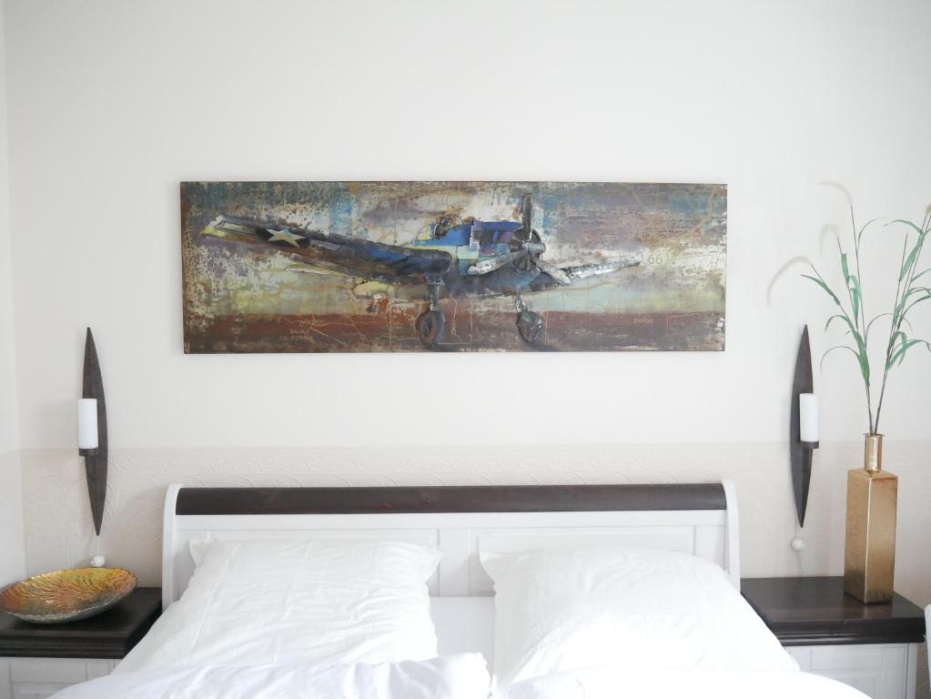 ein Schlafzimmer mit einem Bett mit einem Gemälde darüber in der Unterkunft Ferienzimmer Weltenbummler,Rheinsberg in Rheinsberg