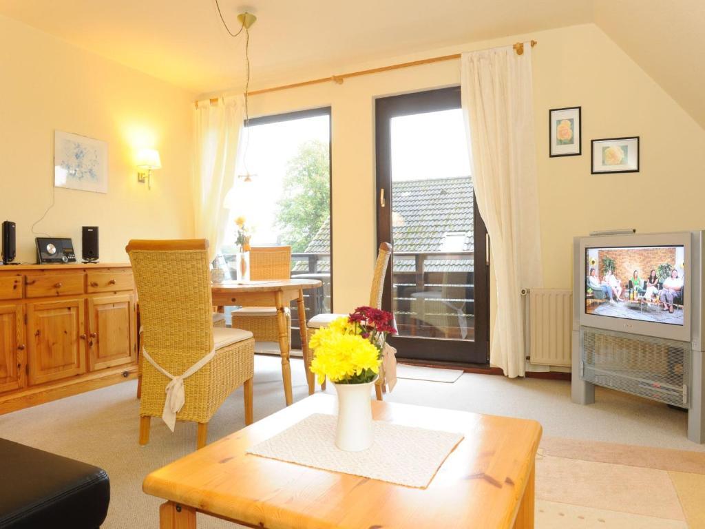 a living room with a table and a tv at La Casa Ferienwohnung Strandweg in Steinberg