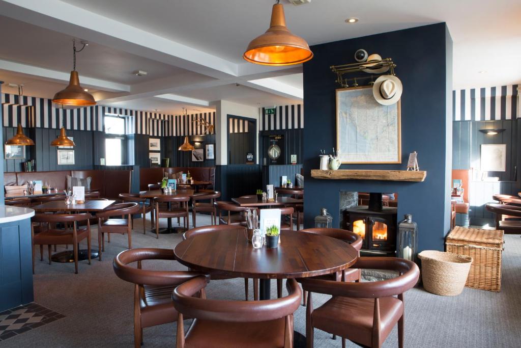 a restaurant with tables and chairs and a fireplace at Seacroft in Holyhead