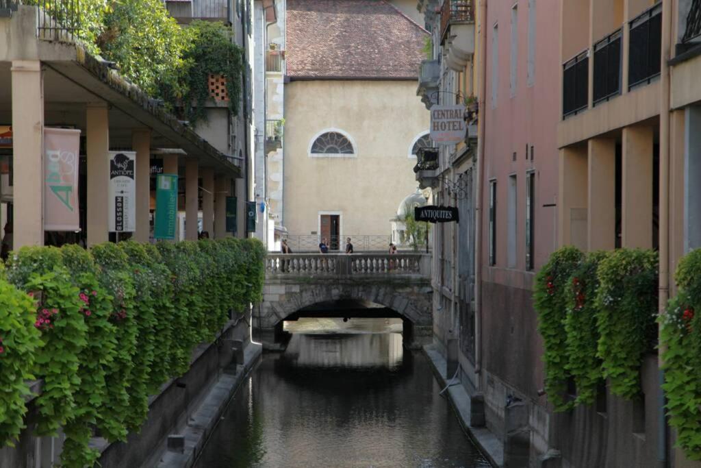 einen Kanal in einer Stadt mit einer Brücke und einem Boot in der Unterkunft LE GRUFFAZ - Hyper centre, Balcon sur canal in Annecy