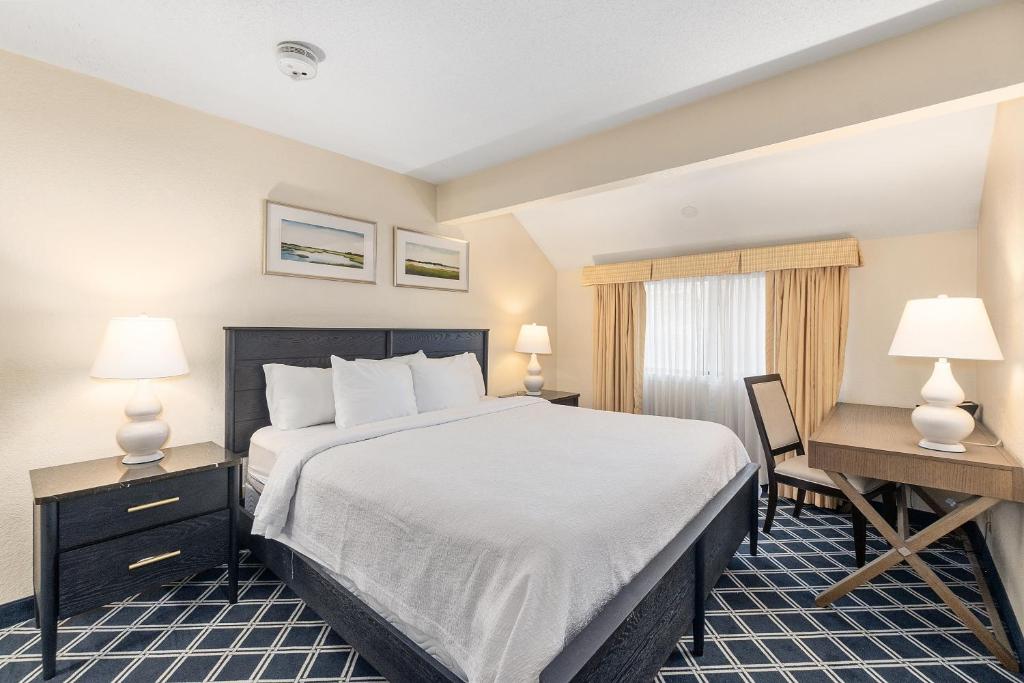 a hotel room with a bed and a desk at Residences at Daniel Webster in Merrimack