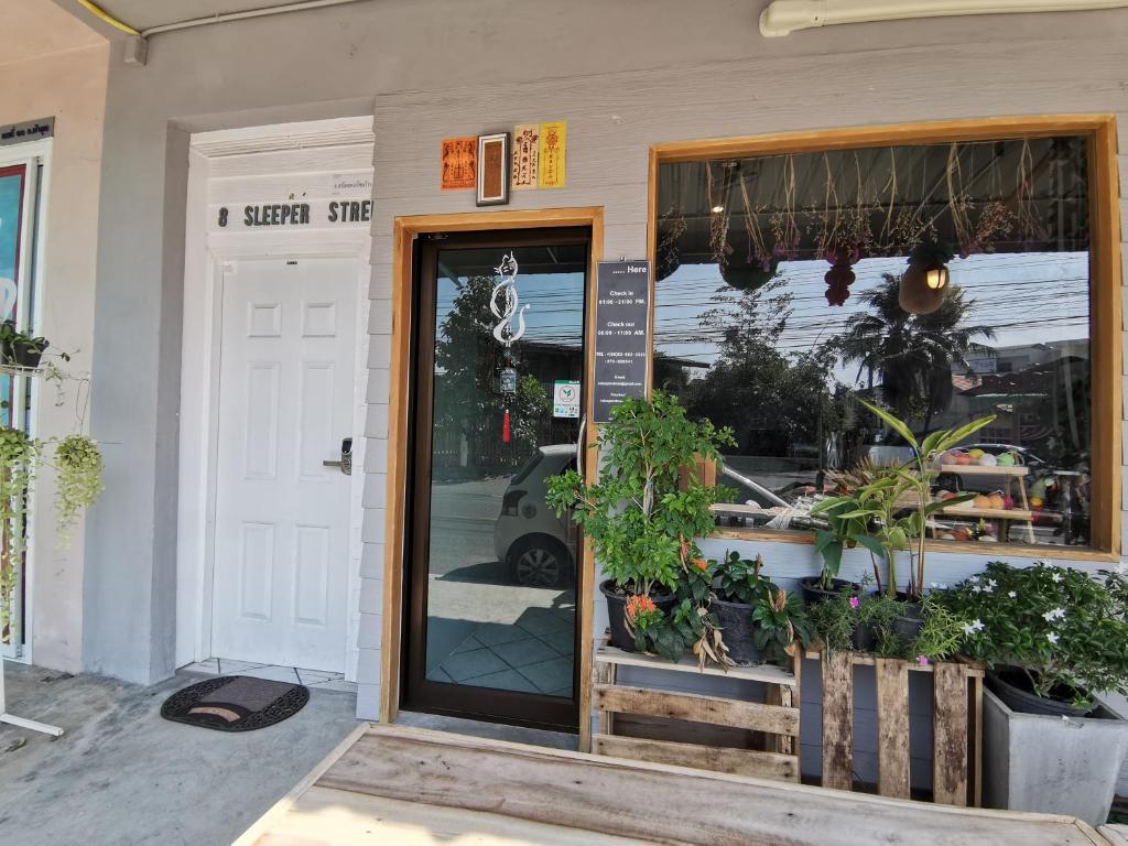 a door to a flower shop with plants outside at 8 SLEEPER STREET Hostel in Krabi