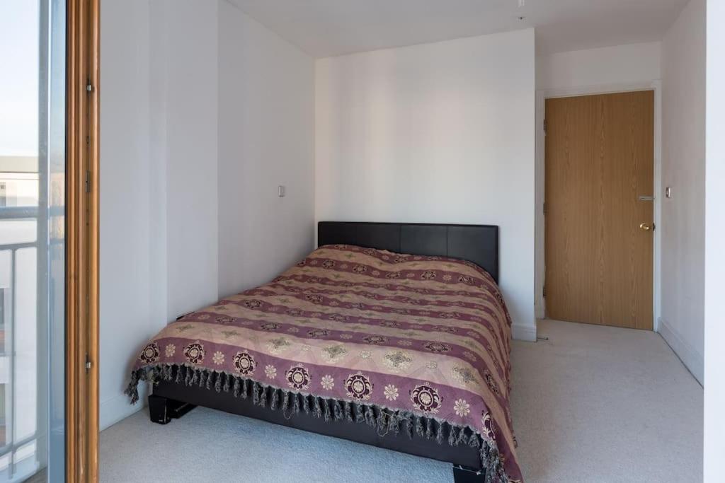 a bedroom with a bed with a brown blanket at City view apartment in Birmingham