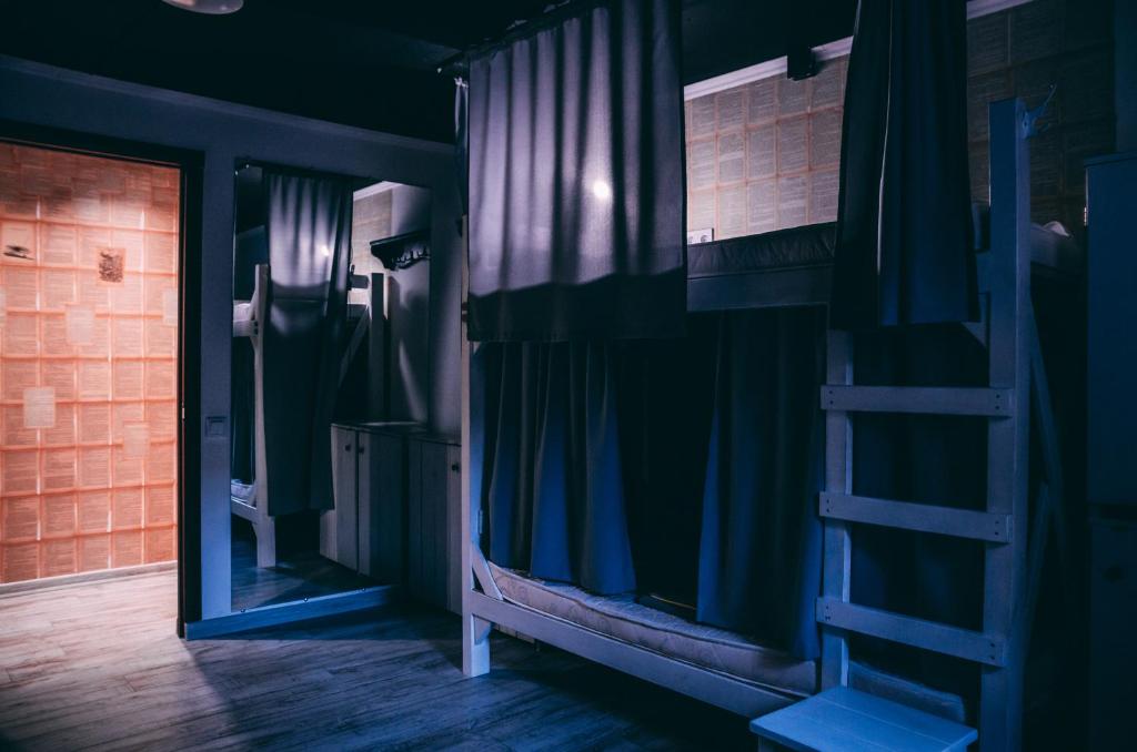 a room with a bunk bed with a ladder and a mirror at Smart Hostel in Odesa