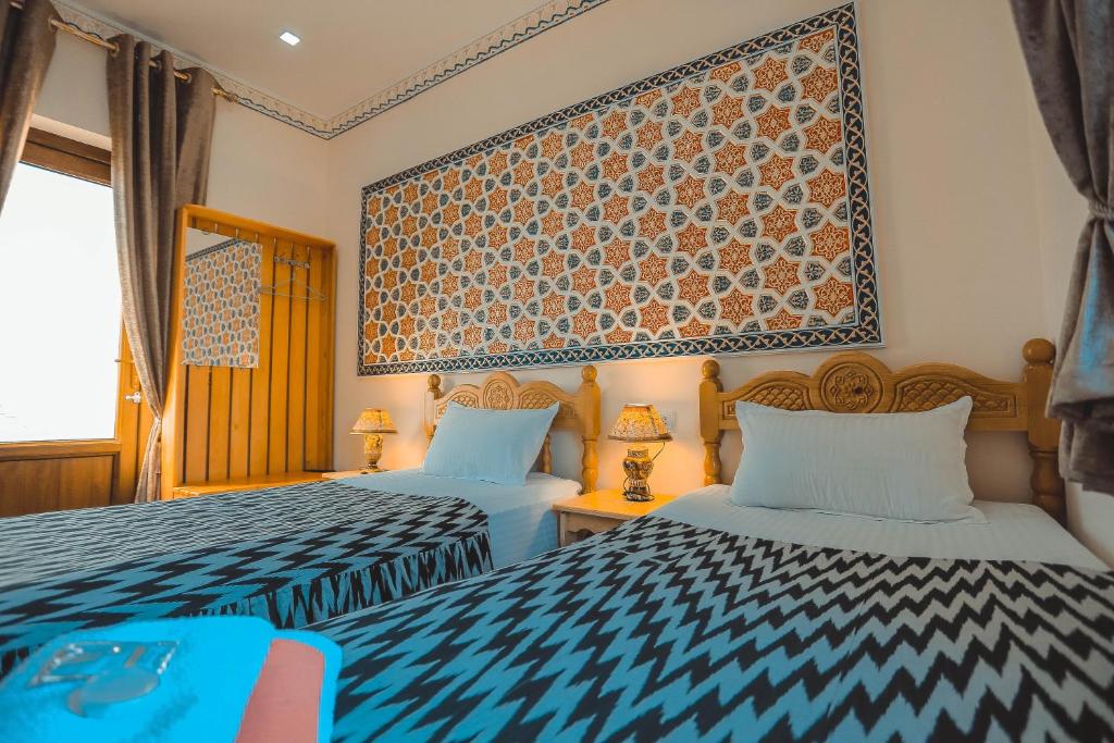 a bedroom with two beds and a large window at Yasmin in Bukhara