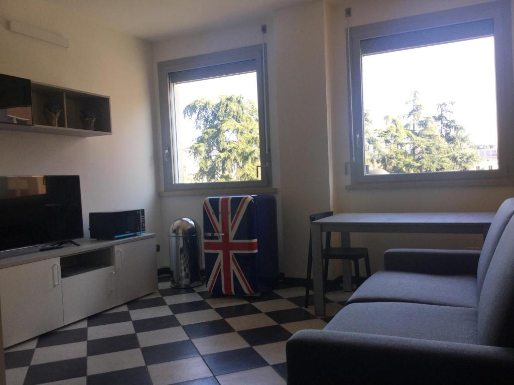 SUB 14 Suite Apartment - Vietato Fumare في ريجيو إيميليا: غرفة معيشة مع أريكة وطاولة ونوافذ