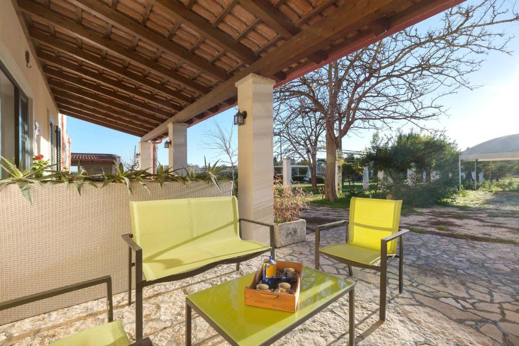 2 sillas amarillas y una mesa en el patio en Casina Farnarari by BarbarHouse, en Monteroni di Lecce