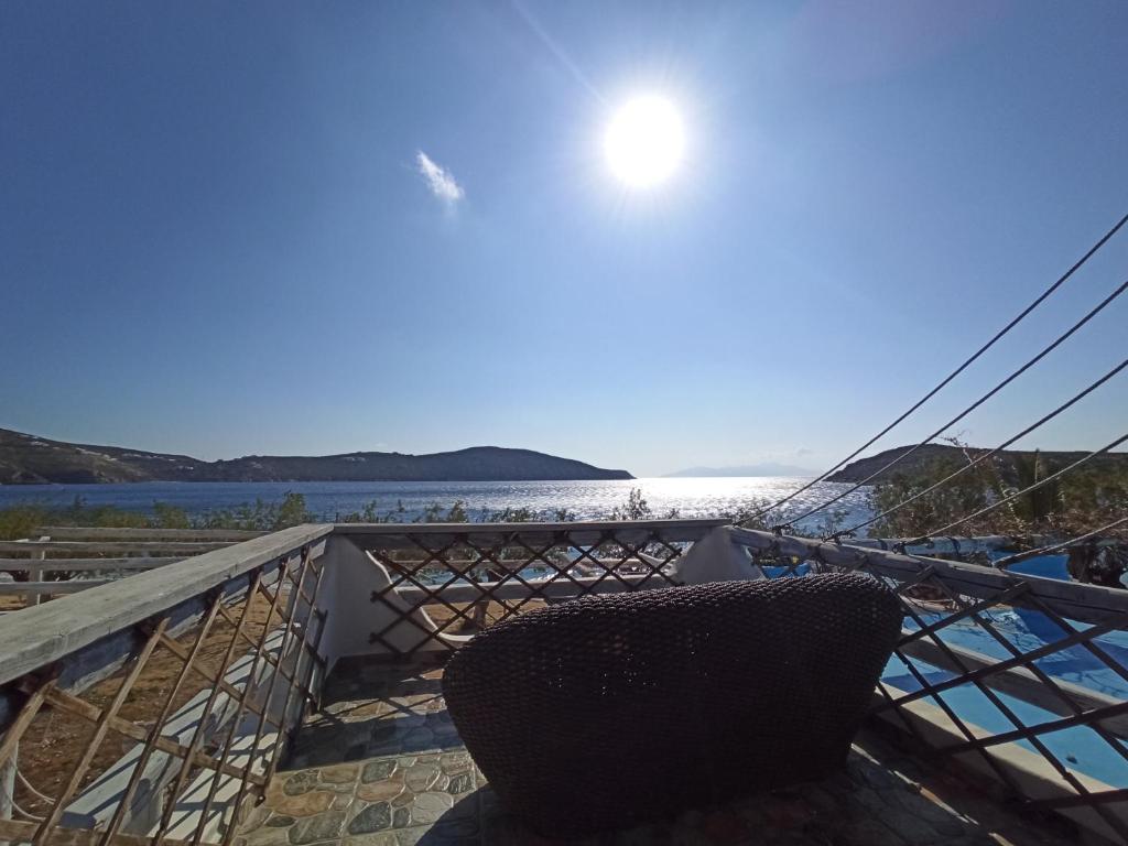a chair on a balcony with a view of the water at Alexandros by the Beach - Serifos in Livadakia