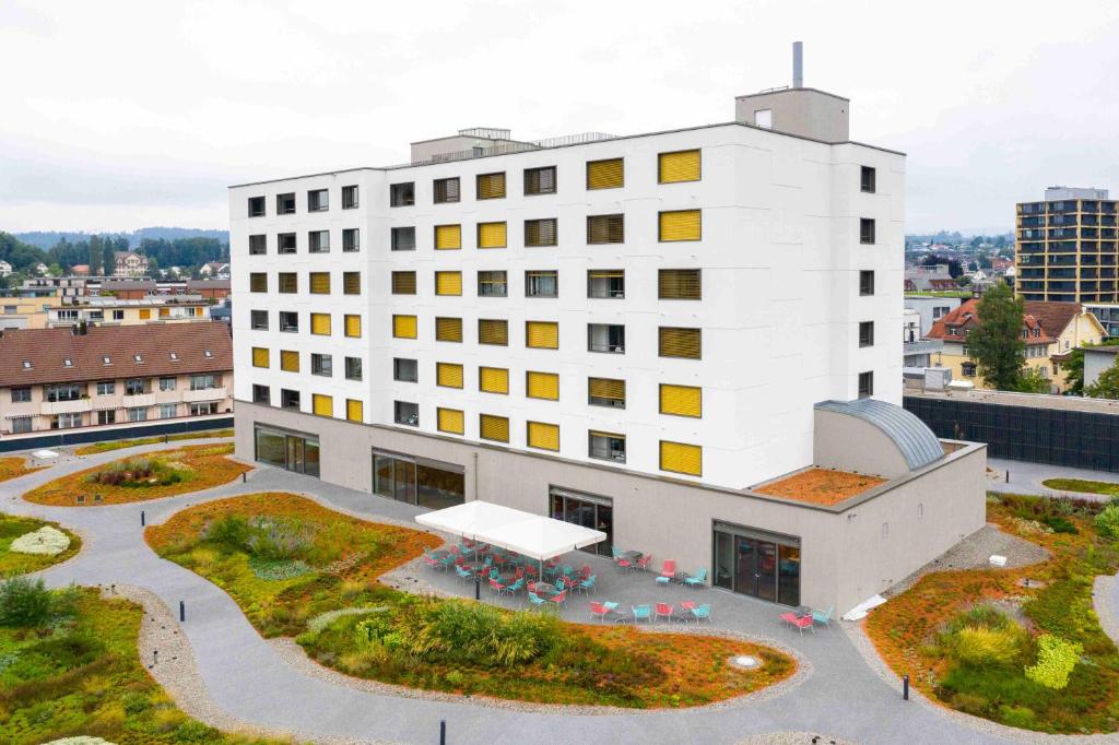 a white building with a courtyard in front of it at HOTEL illuster - Urban & Local in Uster