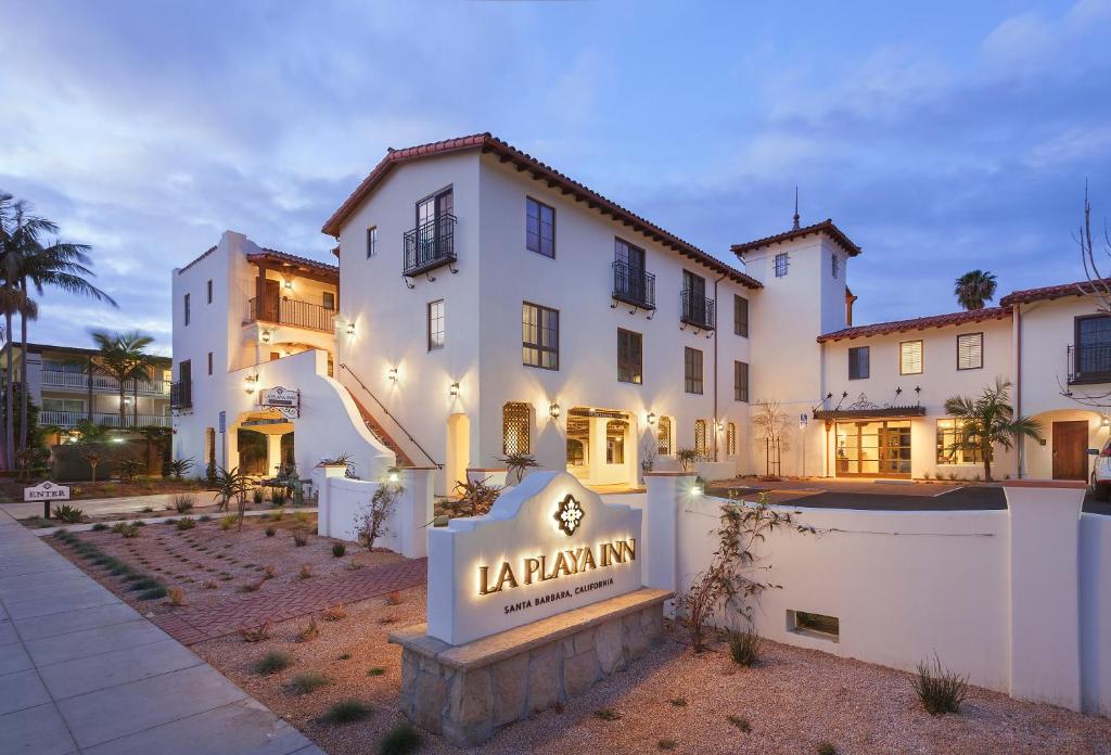 a large white building with a sign in front of it at La Playa Inn Santa Barbara in Santa Barbara