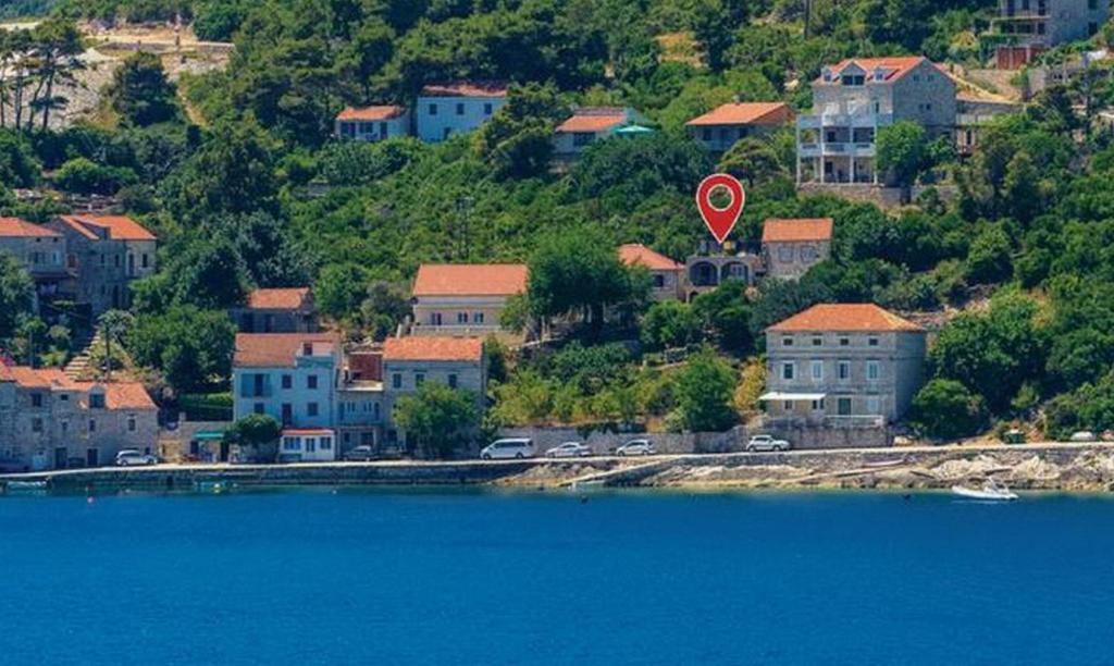 a town with a red kite flying over a body of water at Apartments Vitorin in Sobra