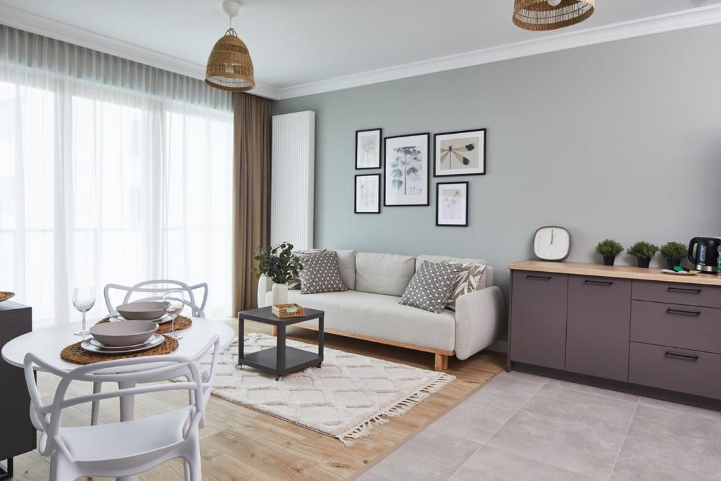 a living room with a couch and a table at Metro Imielin Apartments in Warsaw