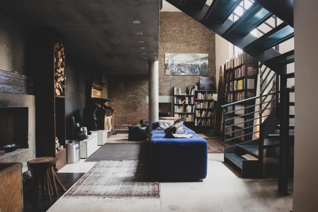 a living room with a blue couch and a staircase at B&B Design in Bologna