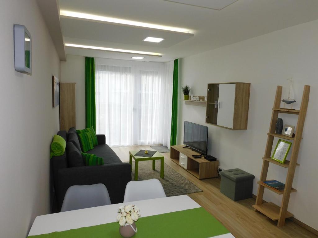 ein Wohnzimmer mit einem Sofa und einem TV in der Unterkunft Katamaran in Siófok