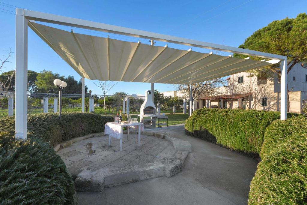 a pavilion with a table under it in a park at Casina Farnarari by BarbarHouse in Monteroni di Lecce
