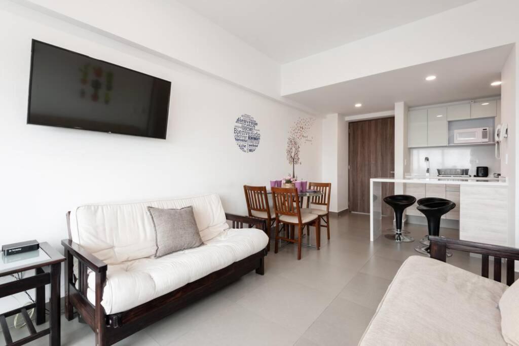 a living room with a couch and a kitchen at San Ángel - UNAM apartment 2parking 3BR 2BA in Mexico City