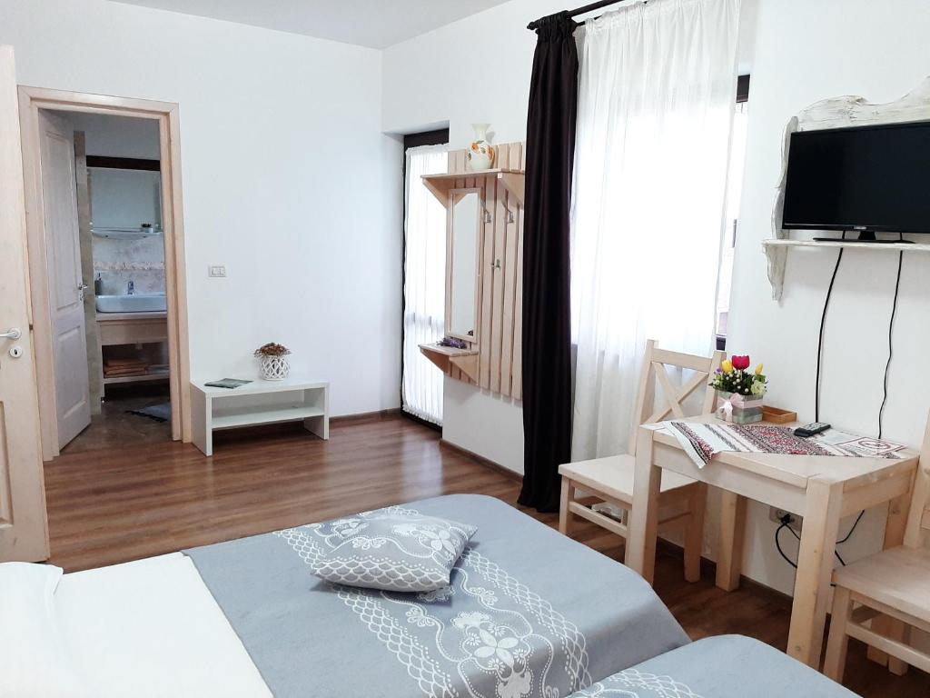mały salon z biurkiem i łóżkiem w obiekcie Dor de Casa w mieście Doljeşti