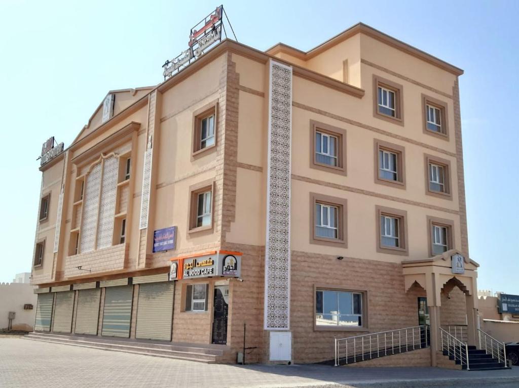 AL JOOD HOTEL APARTMENT في Ḩilf: مبنى كبير امام شارع