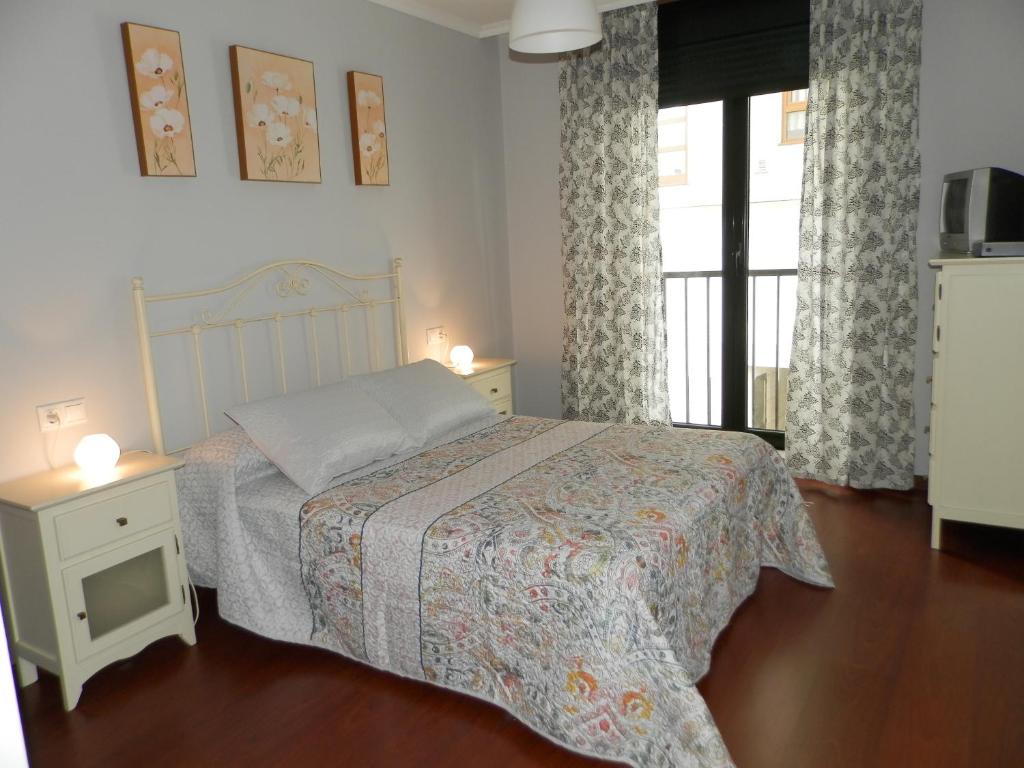 a bedroom with a bed and a window at Apartamento Río Breiro in Boiro