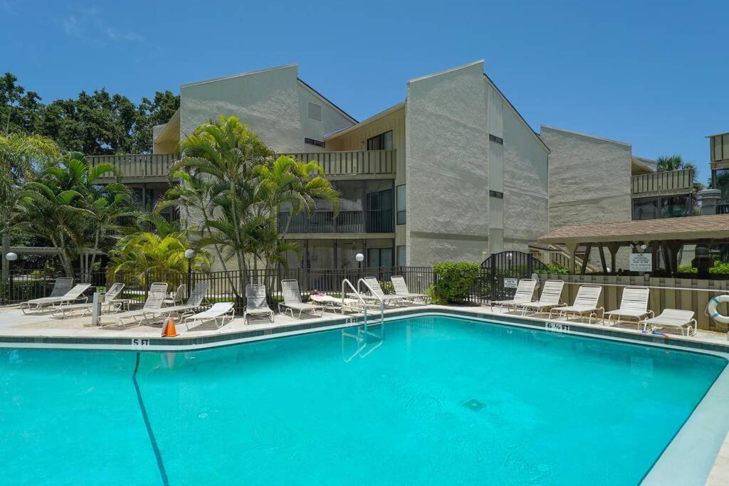 une piscine avec des chaises longues et un bâtiment dans l'établissement Heated Pool-Short Walk to Beach, FREE trolley around Siesta Key!, à Siesta Key