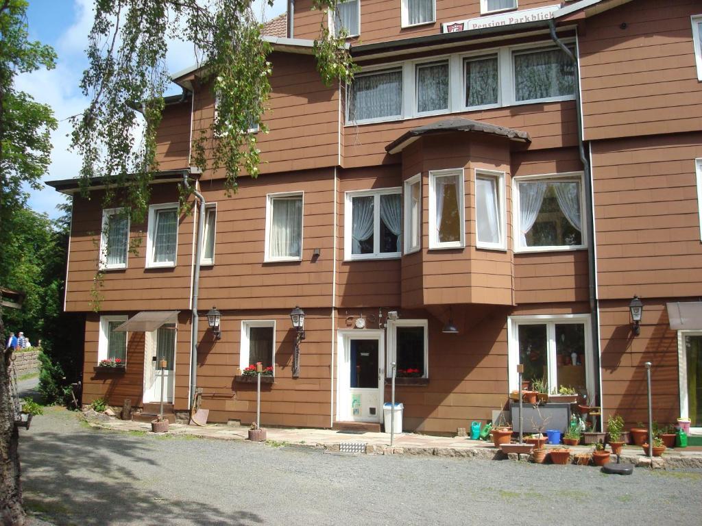 um grande edifício de madeira com portas e janelas brancas em Pension Parkblick em Braunlage