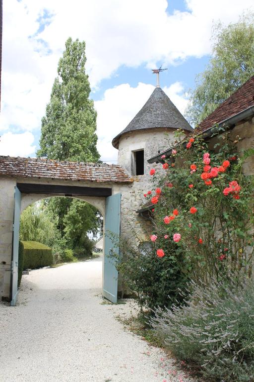 an entrance to a stone church with red roses at Manoir de la Foulquetiere in Luçay-le-Mâle