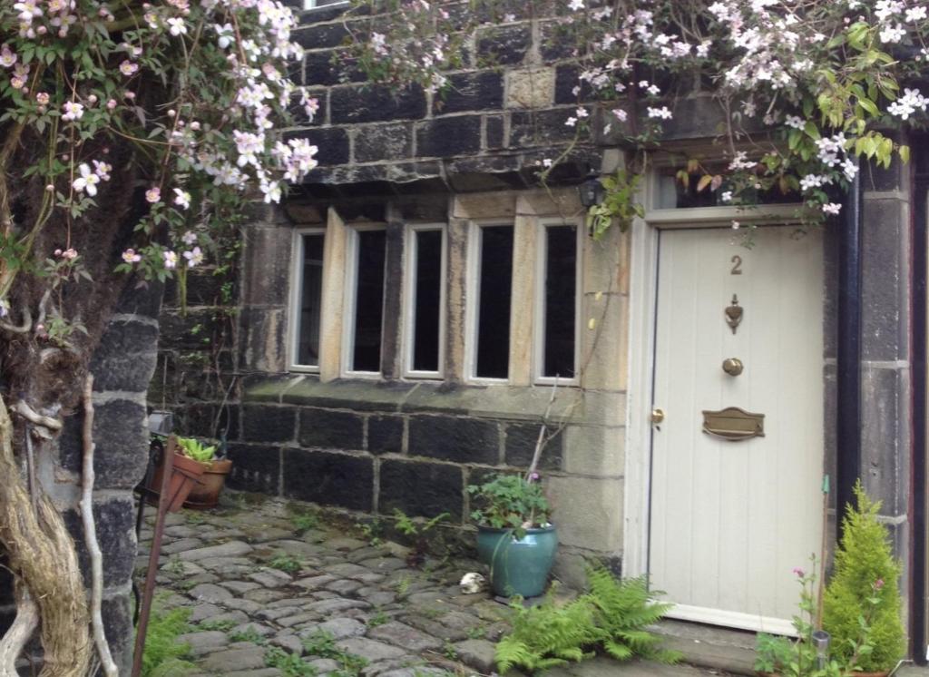 a house with a white door and a window at Swanfold in Hebden Bridge