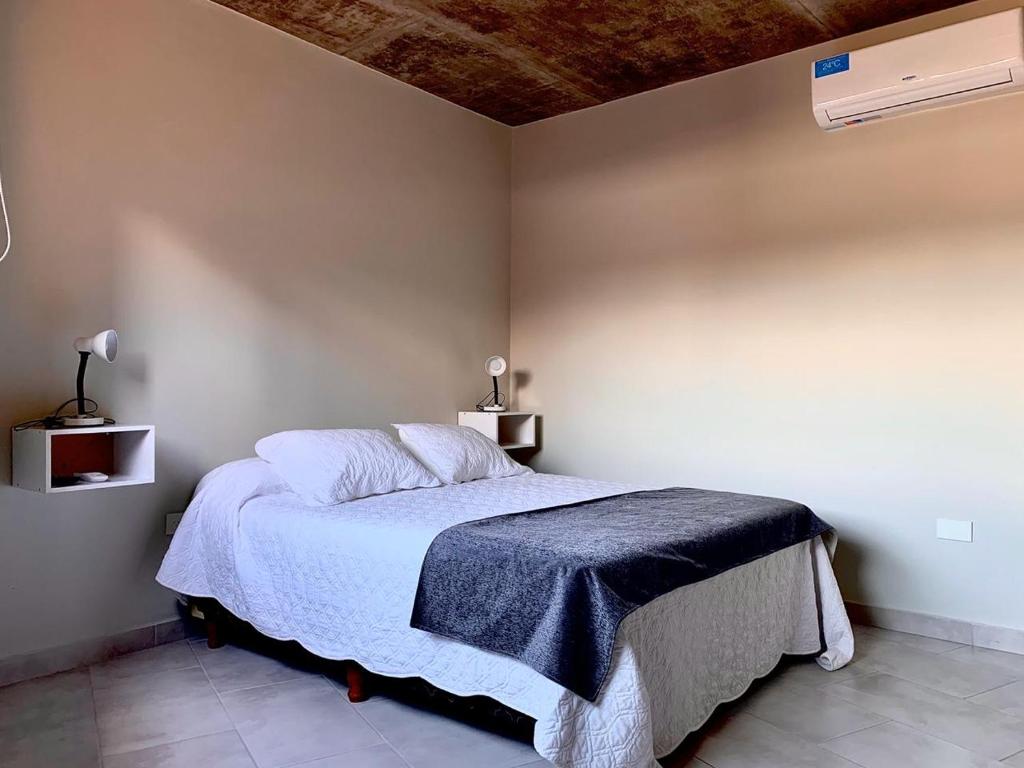 Un dormitorio con una cama con una manta azul. en CERROS del NORTE II Departamentos en San Salvador de Jujuy