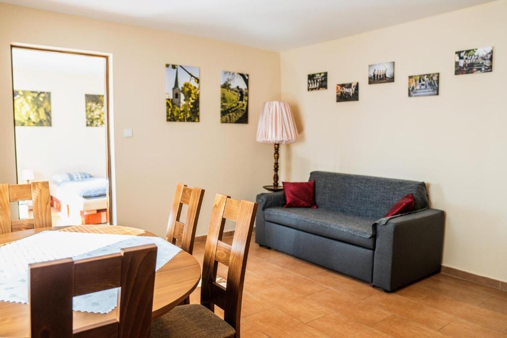 uma sala de estar com um sofá, uma mesa e uma cadeira em Ubytování ve Vinařství Medek | Medek House & Winery em Uherské Hradiště