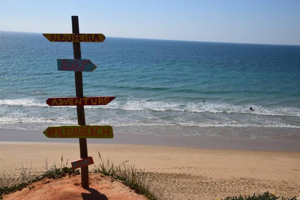 uma placa de rua numa praia com o oceano em Buganvília Apartment Praia da Falésia em Albufeira