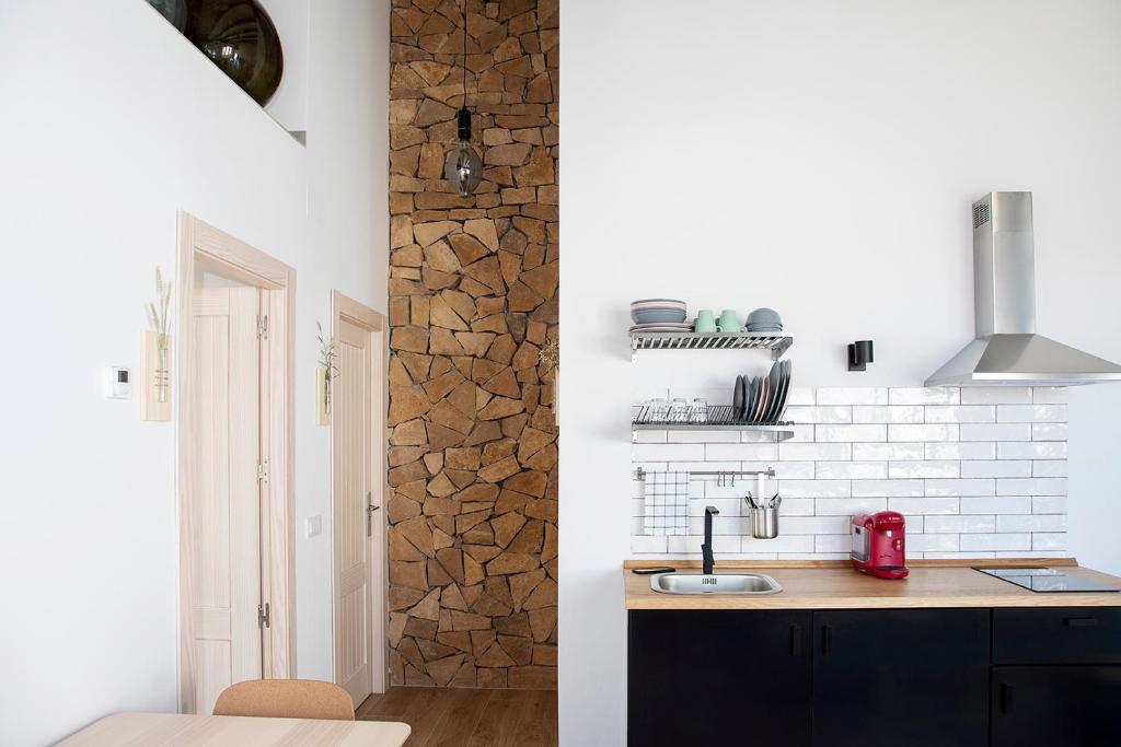 uma cozinha com paredes brancas e um balcão com um lavatório em Alojamiento rural La Moravieta em Pozoamargo