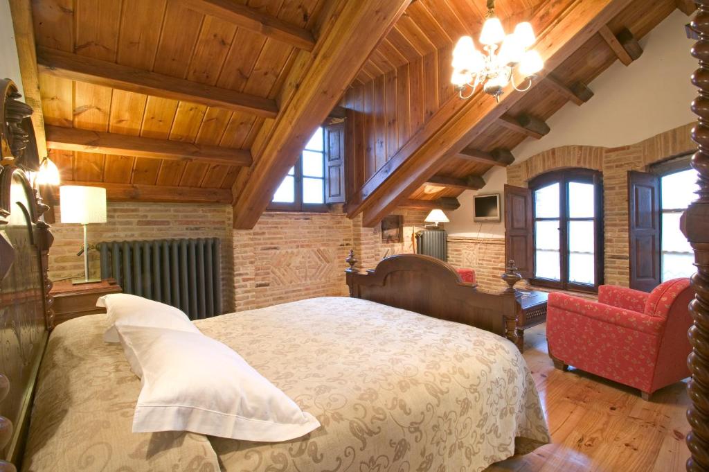 a bedroom with a large bed in a room with wooden ceilings at Hostería Camino in Luyego de Somoza