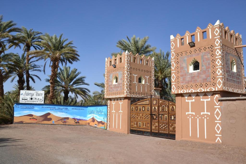a model of a building with palm trees in the background at Mhamid Auberge Saharaespace in Mhamid