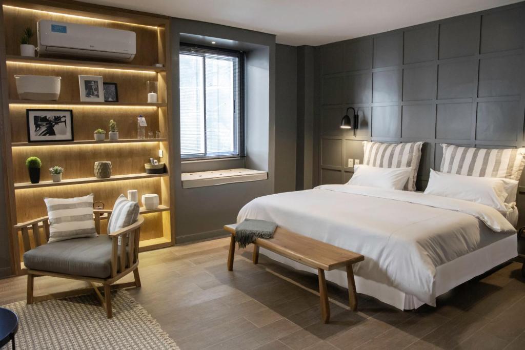 1 dormitorio con 1 cama grande y 1 silla en Carsson Hotel Downtown Buenos Aires en Buenos Aires