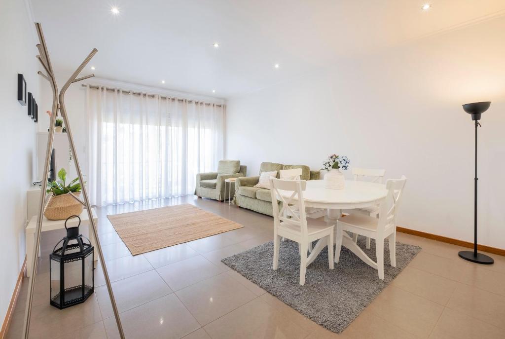 uma sala de estar com uma mesa branca e um sofá em Paim Apartments em Ponta Delgada