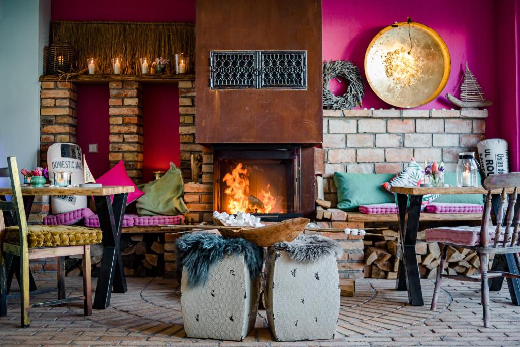 a fireplace in a room with tables and chairs at feels Beach Club Hotel in Kühlungsborn