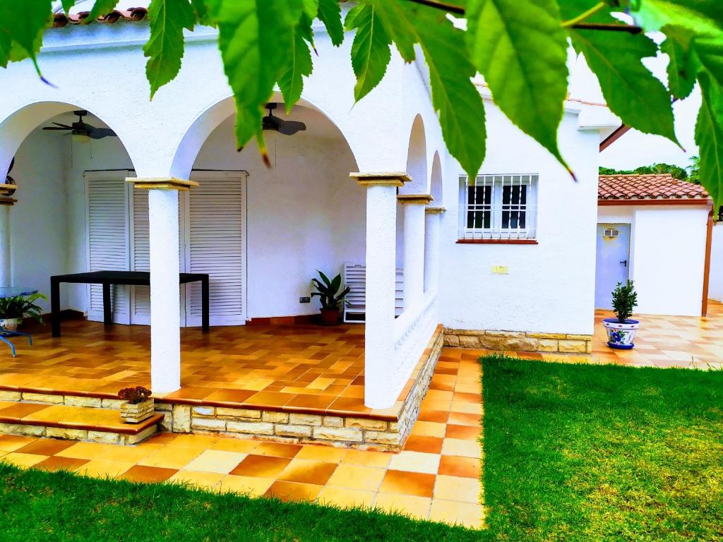 ein weißes Haus mit kariertem Boden und Säulen in der Unterkunft Villa Cambrils Beach in Cambrils