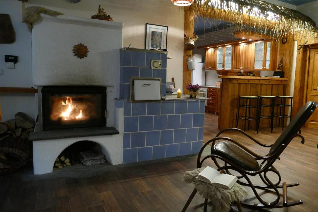 a living room with a fireplace and a chair in front of it at Chalupa Pohoda in Velké Karlovice