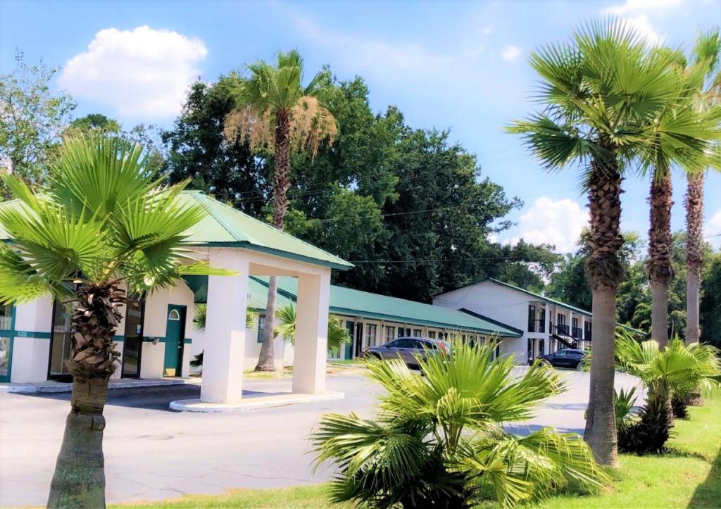 un motel avec des palmiers devant dans l'établissement Relax Inn Savannah, à Savannah