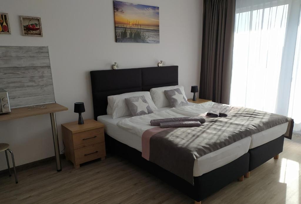 a bedroom with a large bed in a room at Tip Top Apartments Kasprowicza in Kołobrzeg