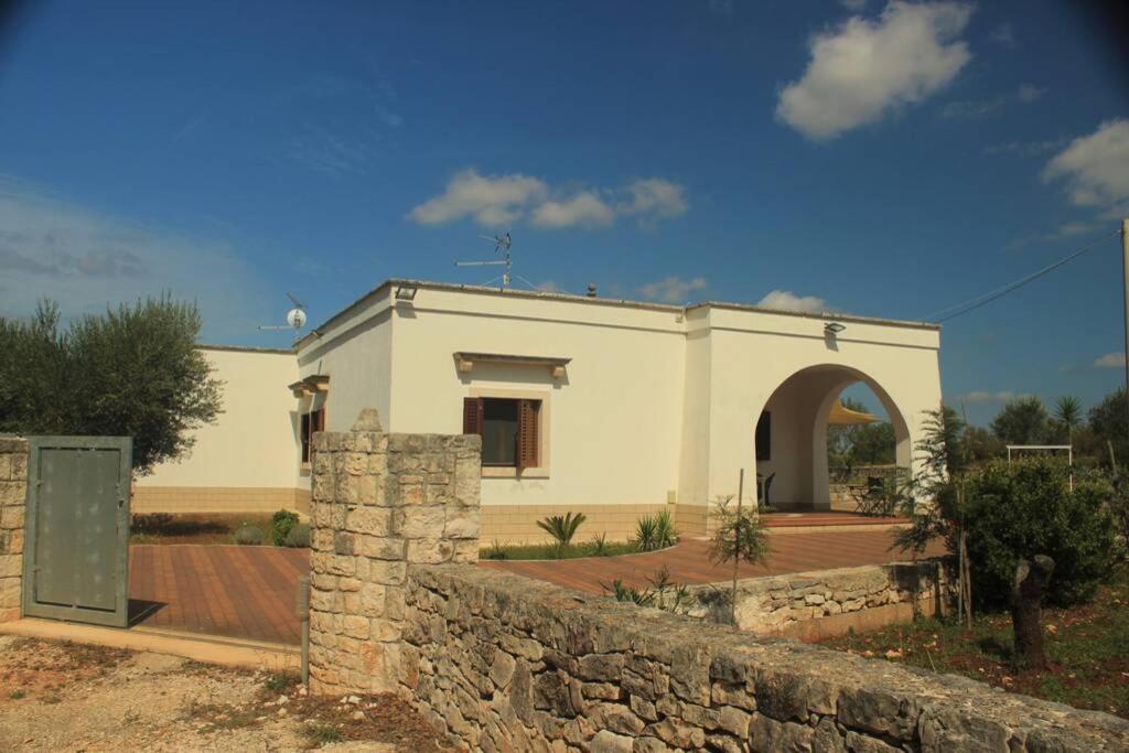 - un petit bâtiment blanc avec un mur en pierre dans l'établissement Il Trullo di Leonardo - casa uso turistico, à Martina Franca