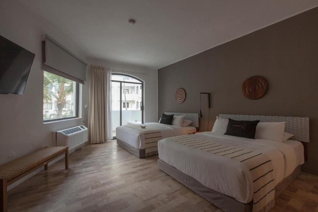 a hotel room with two beds and a couch at Gaviana Resort in Mazatlán
