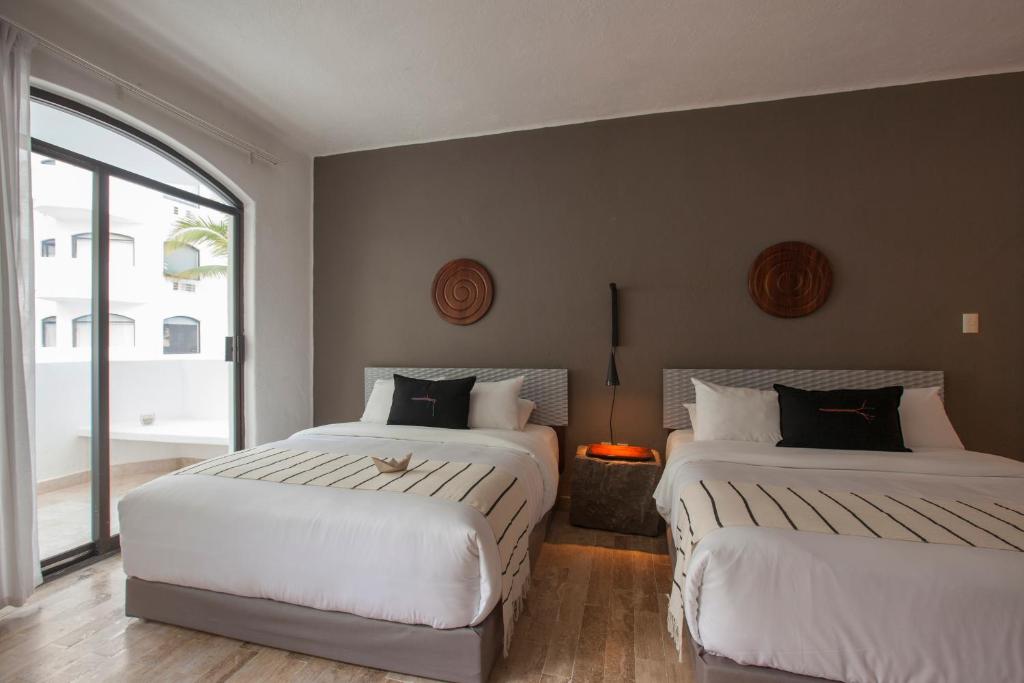 a bedroom with two beds and a window at Gaviana Resort in Mazatlán