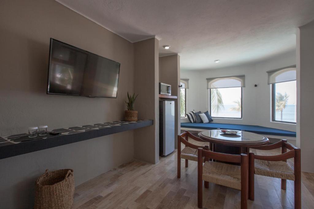 a living room with a table and a tv on the wall at Gaviana Resort in Mazatlán
